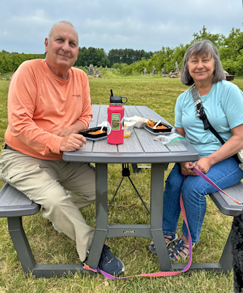 Outside at a picnic table in the grass